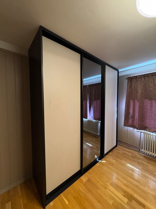 Garderobe met drie schuifdeuren, twee witte en één spiegeldeur